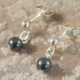 Oorhangertjes Hematiet en zilver: glanzende hematietsteentjes van ca. 5 mm diameter aan een zilveren bolletje.
