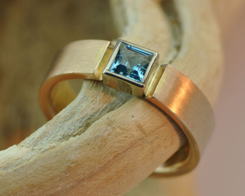 Gouden ring met topaas: roodgouden ring met vierkante blauwe topaas