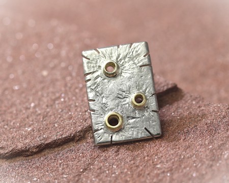 Unieke zilveren reversknoop met gouden elementjes en bijzondere bewerking. Fijnzinnig sieraad, handgemaakt door LYAM edelsmeden